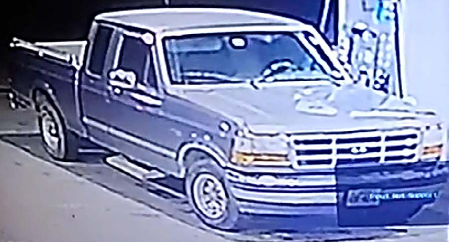 Camera footage photo of suspect's grey 1992-1996 Ford truck parked at the gas station.